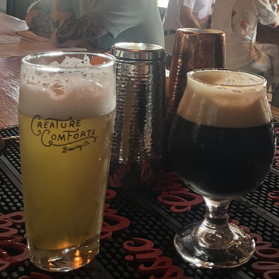 A hazy pale beer and a dark beer side by side on the bar
